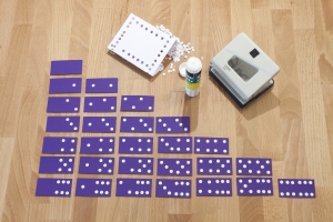 Voor het punten spel van domino, maak je met een pons of perforator rondjes die je vervolgens op plakt.