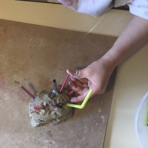 Laat je kind of kinderen de vorm versieren met de gekozen materialen - in dit geval rietjes