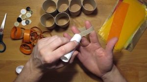 smeer de kokertjes wc-papier-rolletjes in door twee vingers door het kokertje te steken.