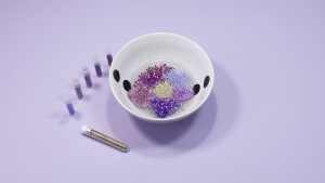Pak de uitgekozen glitters en doe deze in de lijm