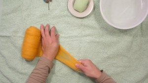 Trek voorzichtig een stukje wol van het rolletje, en bedenk dat het bolletje ongeveer 2/3 slinkt