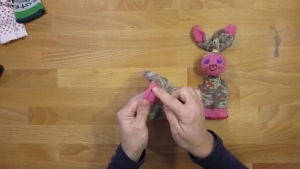 Verdeel de sok in drie delen zodat er zometeen een hoofd en lijfje ontstaat in je handpopje